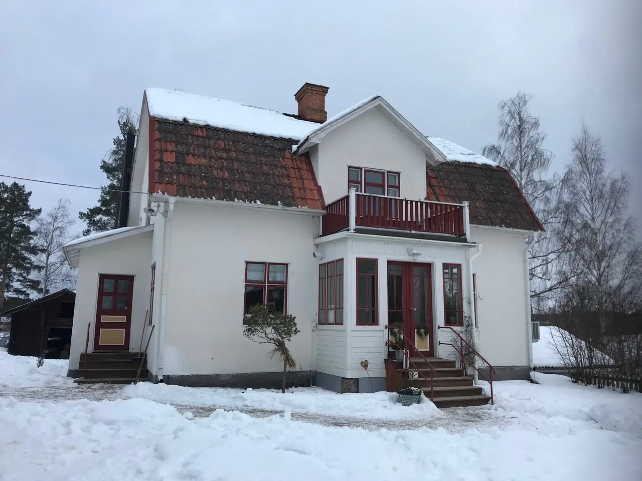 Vitt hus med mörkt tak under vintern