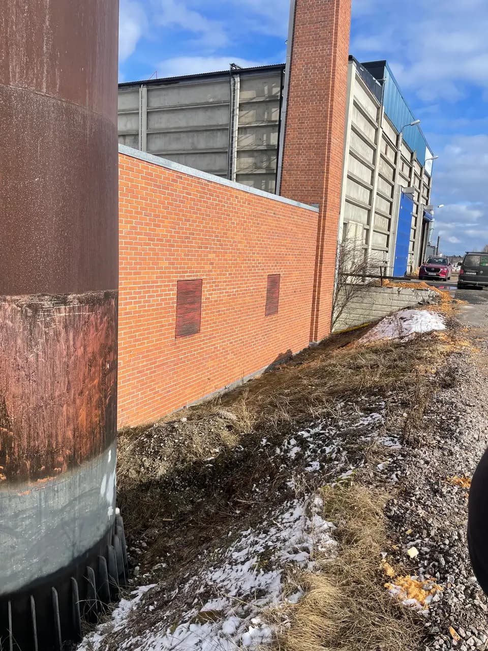 Dränering och grundarbete vid tegelfasad på industribyggnad
