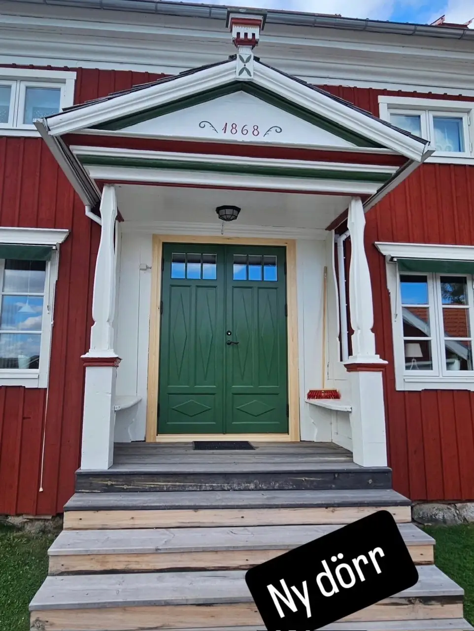 Renoverad entré med grön dörr och originaldetaljer