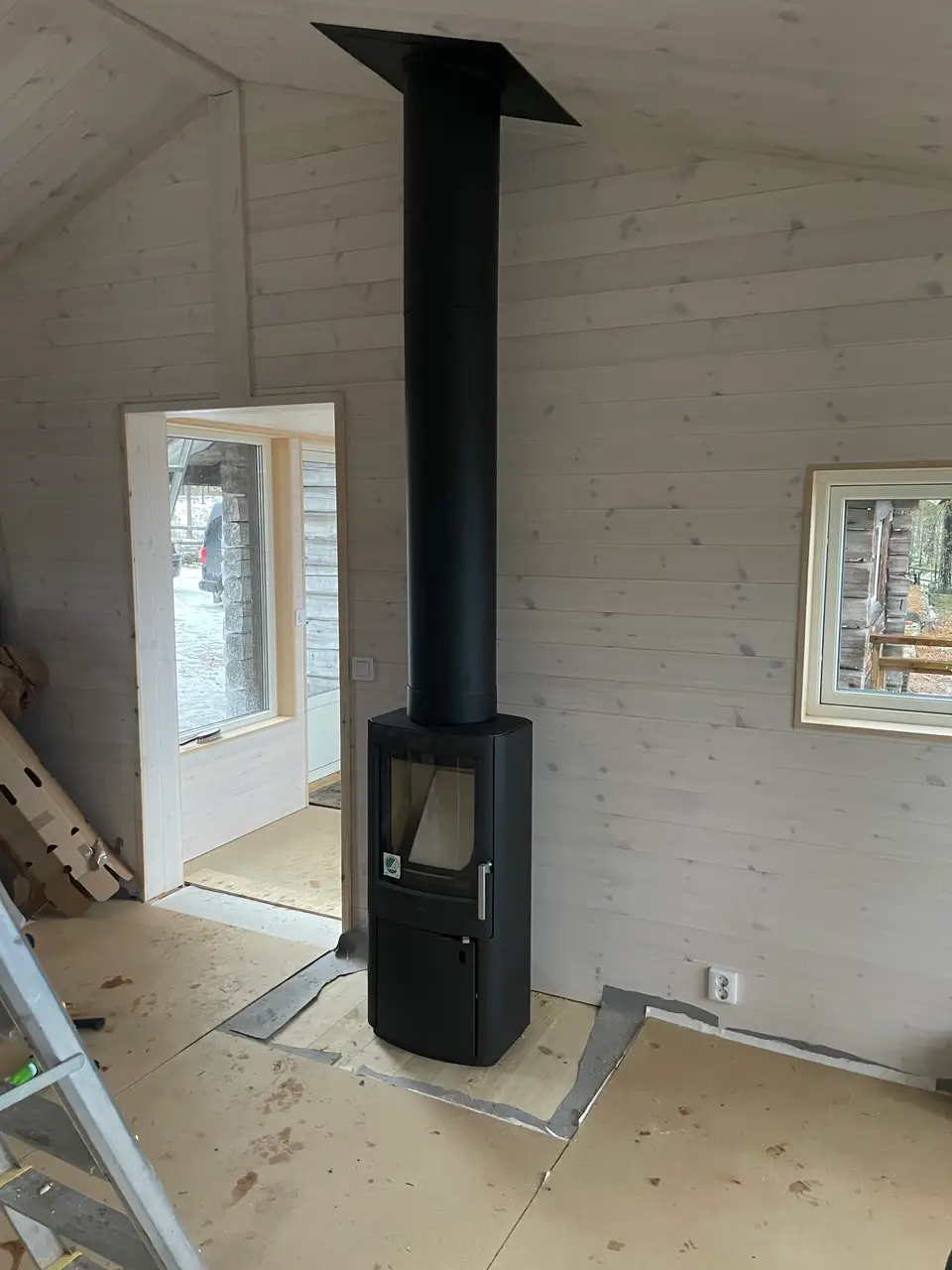 Nyinstallerad vedspis i renoverat rum