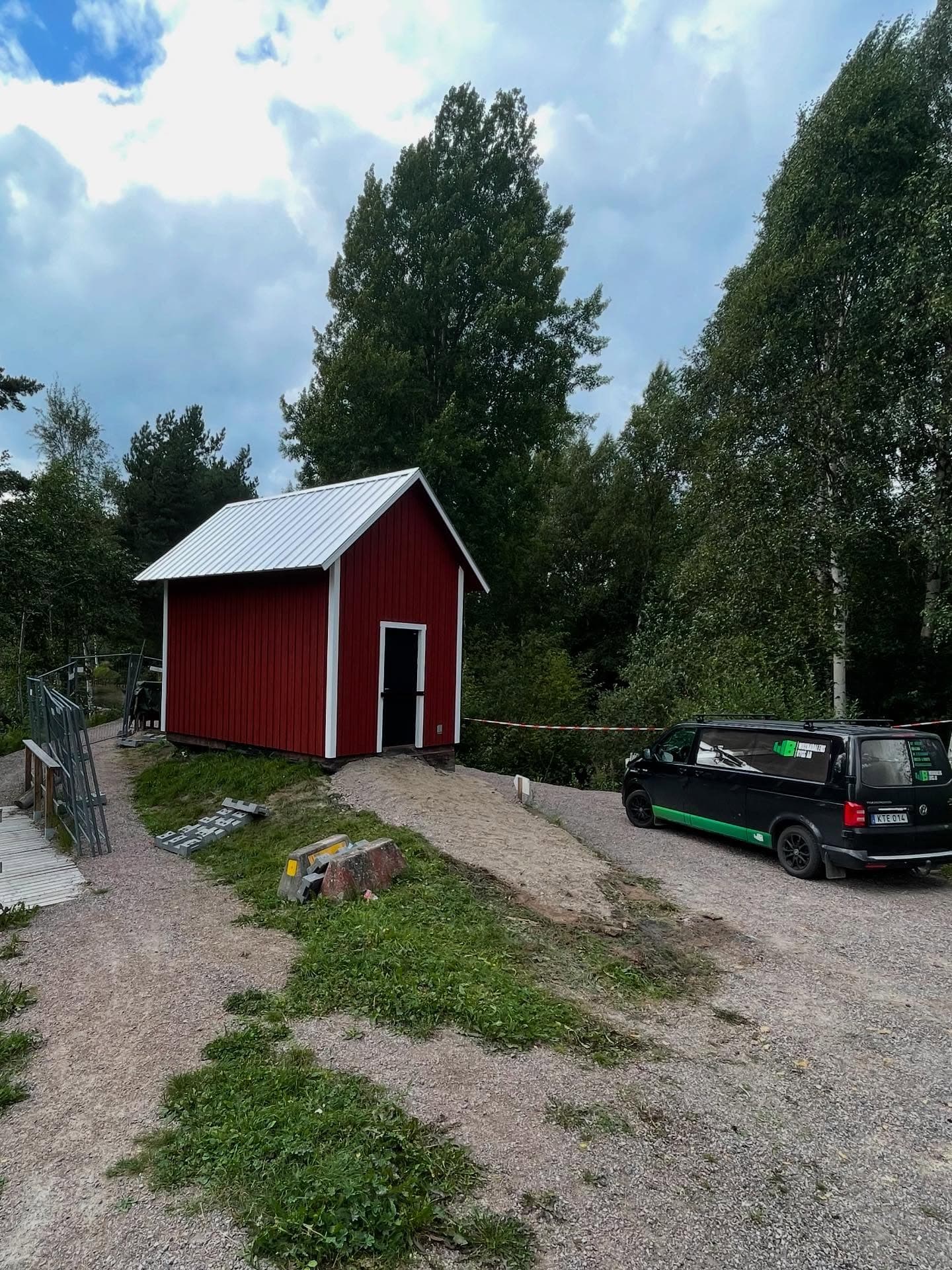 Nybyggt rött pumphus med vitt plåttak och vita knutar, med företagets servicebil bredvid